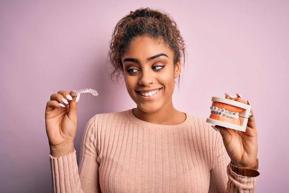 Young,african,american,woman,smiling,happy,holding,professional,orthodontic,denture