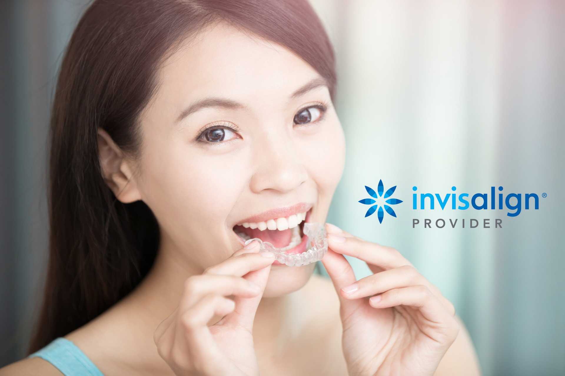 woman holding invisalign retainer up to mouth