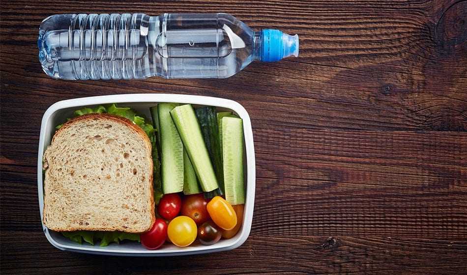 Water bottle and container with sandwich and fresh vegetables