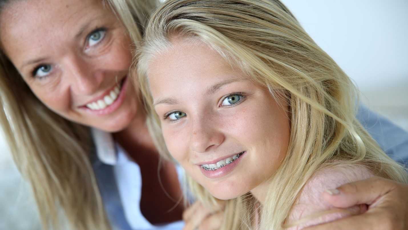Mother And Daughter Smile At Camera
